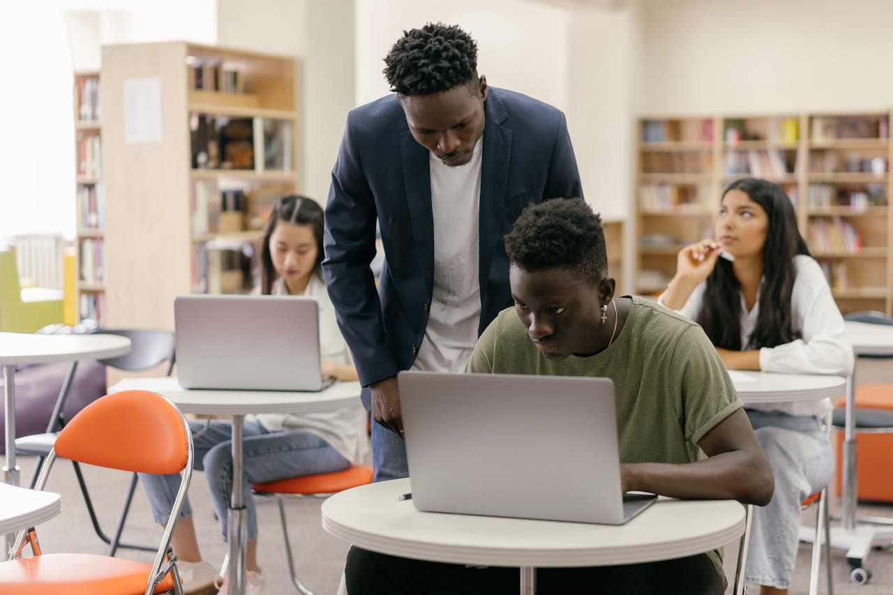 A Man in Blazer Looking at the Students Work